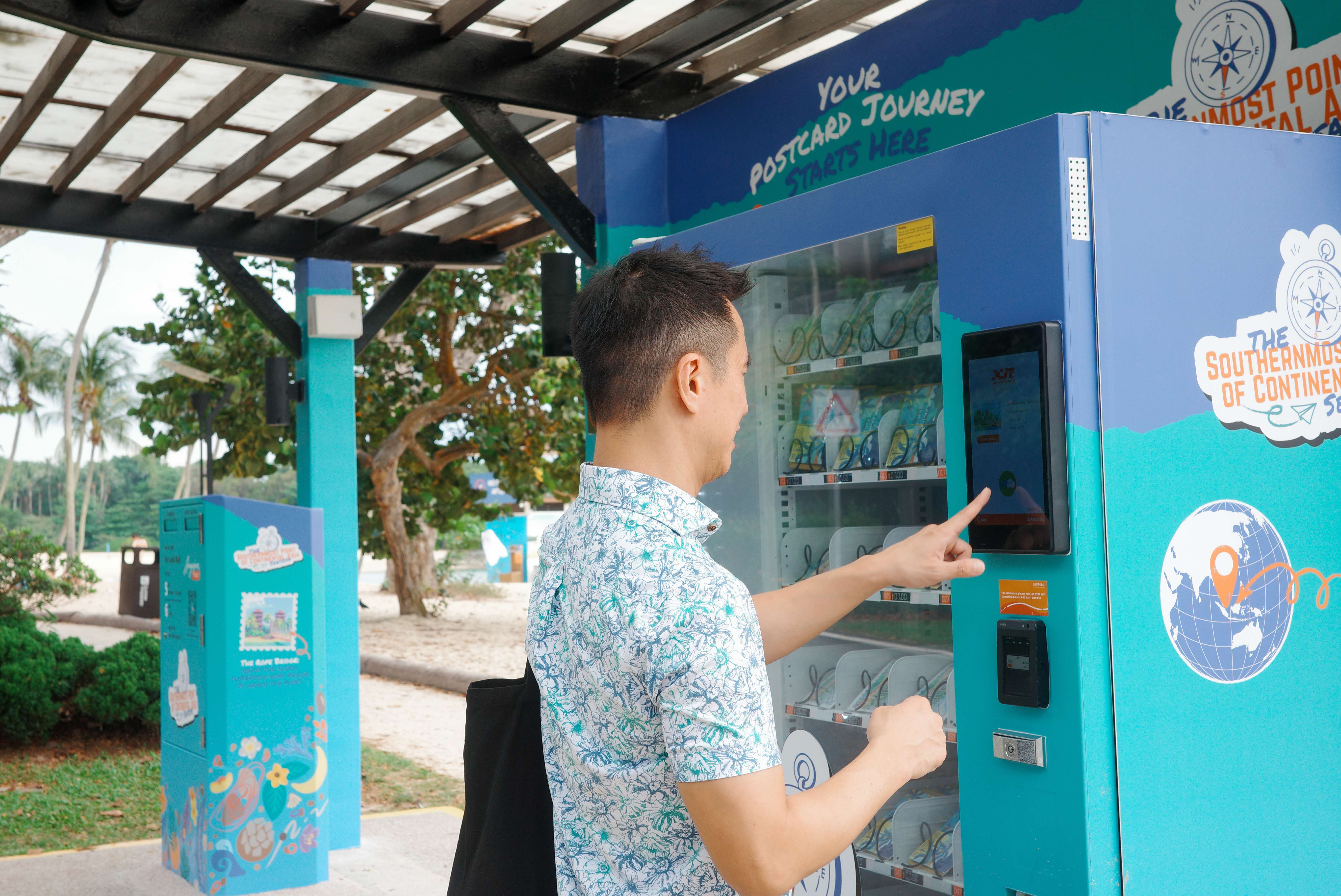 Man buying a postcard set from a blue vending machine